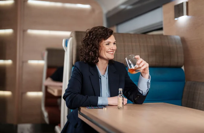 Professional woman enjoying a drink on board the Caledonian Sleeper.