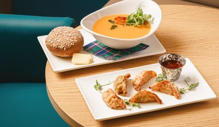 Selection of starters including a bowl of soup and a plate of gyozas.