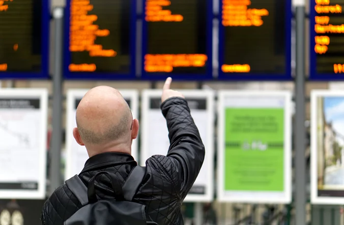 Man pointing at departure board at Glasgow Central
