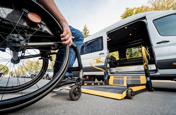 Wheelchair user entering accessible taxi