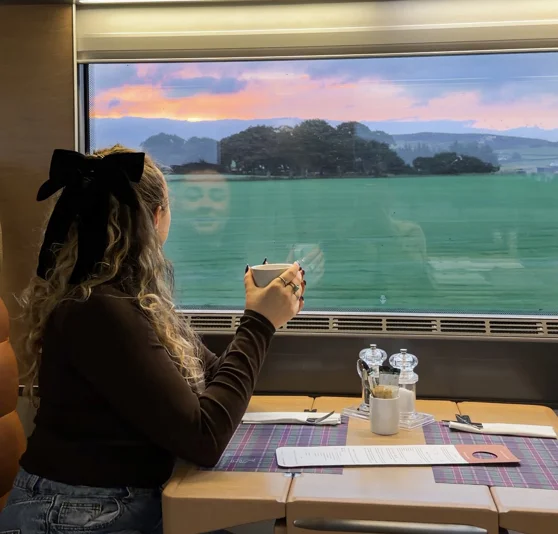 Kirsty watching the sunrise over the ocean from the Caledonian Sleeper Club Car.