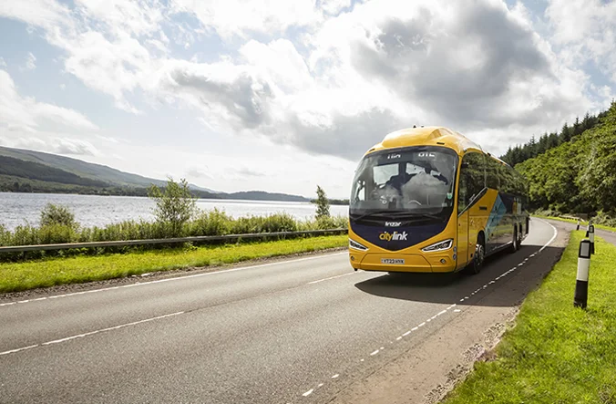 A Citylink coach travelling through a rural landscape.