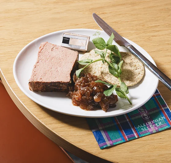 A plate of Pork and Duck Liver pate, with salad garnish and crackers.