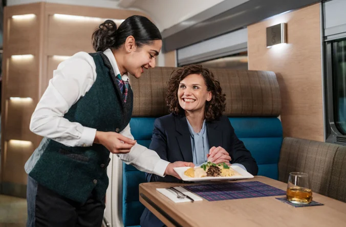 Professional woman enjoying an evening meal on board the Caledonian Sleeper.