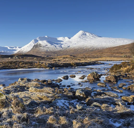 Rannnoch Moor with snow capped mountains in background.