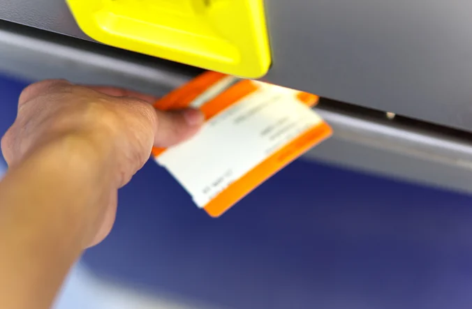 Ticket machine with ticket coming out the bottom of it