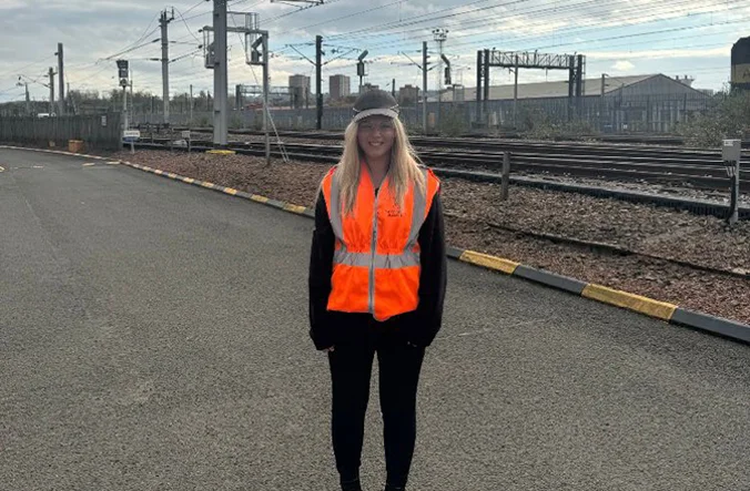 Person in high vis jacket working on a Caledonian Sleeper train.