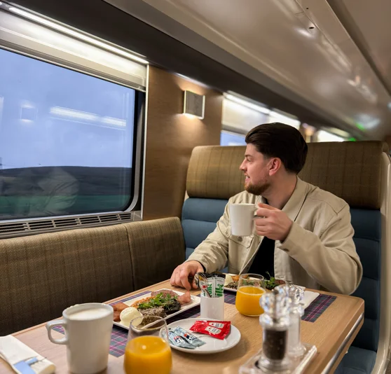 A man enjoying a meal in the Caledonian Sleeper Club Car.