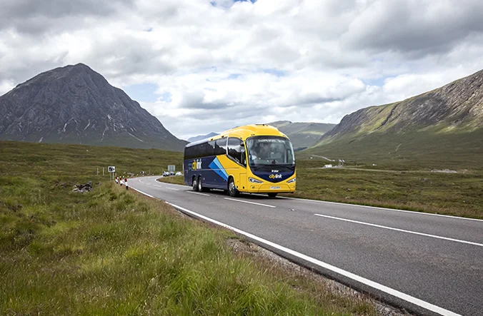 A Citylink coach travelling through a rural landscape.