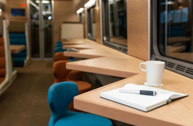 Notebook and cup of tea at seats by window in Club Car