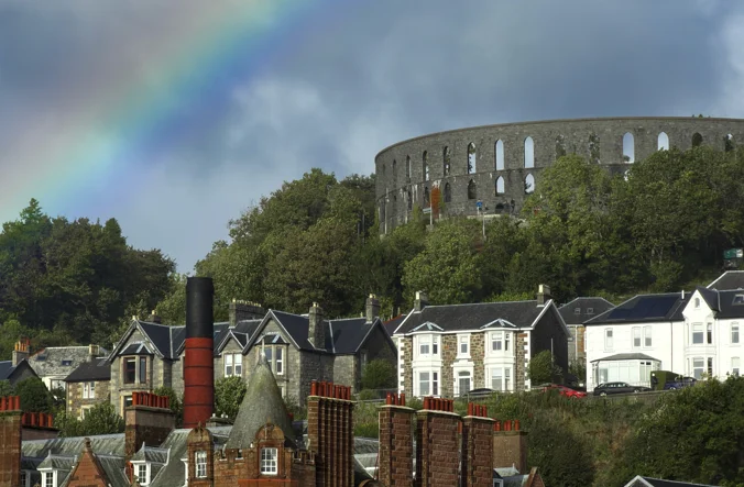 Rainbow over the rooftops and skyline of Oban.