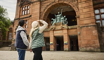 A couple standing at the front of the Kelvingrove Art Gallery and Museum.