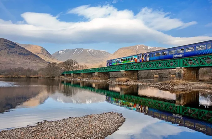 Train travelling through Scottish landscape.