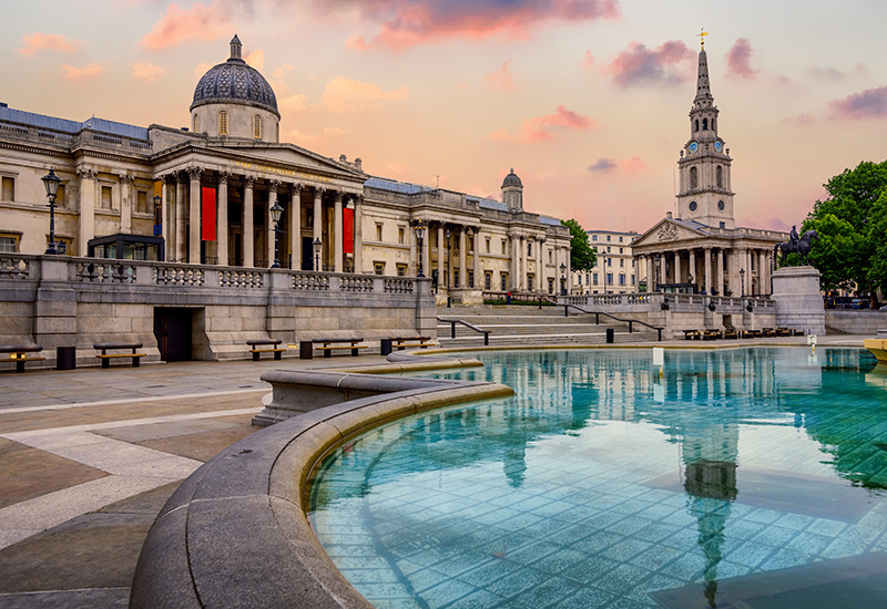 The Trafalgar square in London, England, with National Gallery and St Marting on the Fields church in dramatic light